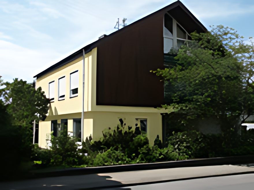 Dasselbe Wohnhaus nach der Renovierung: frischer Anstrich in warmem Gelb